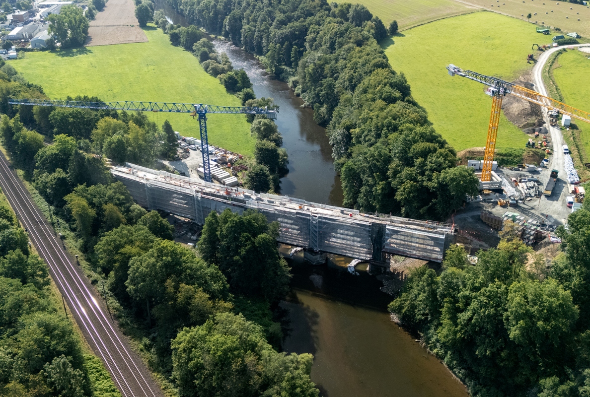 Perfectly planned for efficient lifting operations. BKL positioned the two heavy-duty cranes on opposite banks of the river, with radii of 70 and 80 metres. The cranes thus covered the entire length of the bridge – almost 170 metres – without the need for time-consuming crane reassembling.<br>IMAGE SOURCE: Albert Weil AG